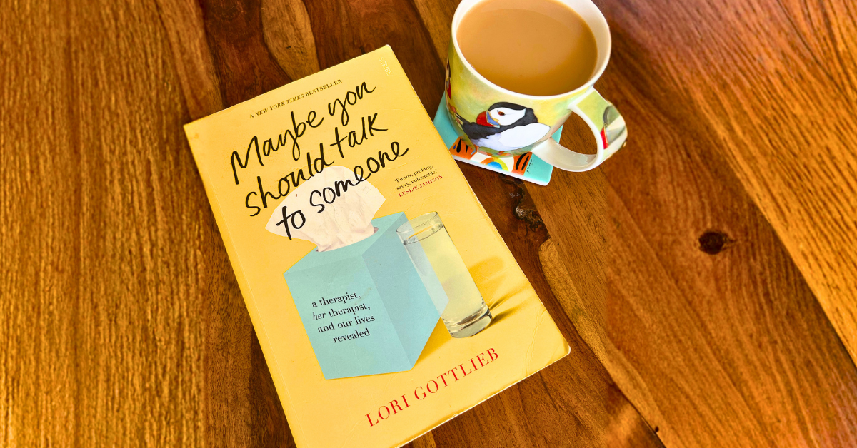 Yellow book on a coffee table beside a cup of tea